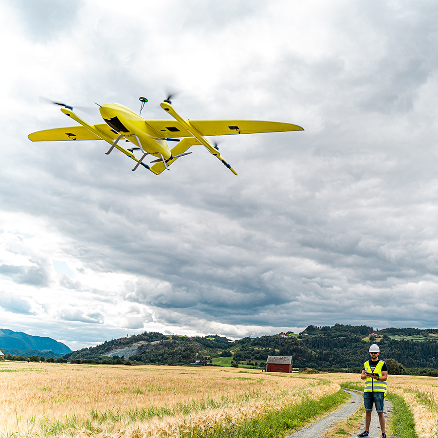 An image of a drone hovering, being controlled by an operator