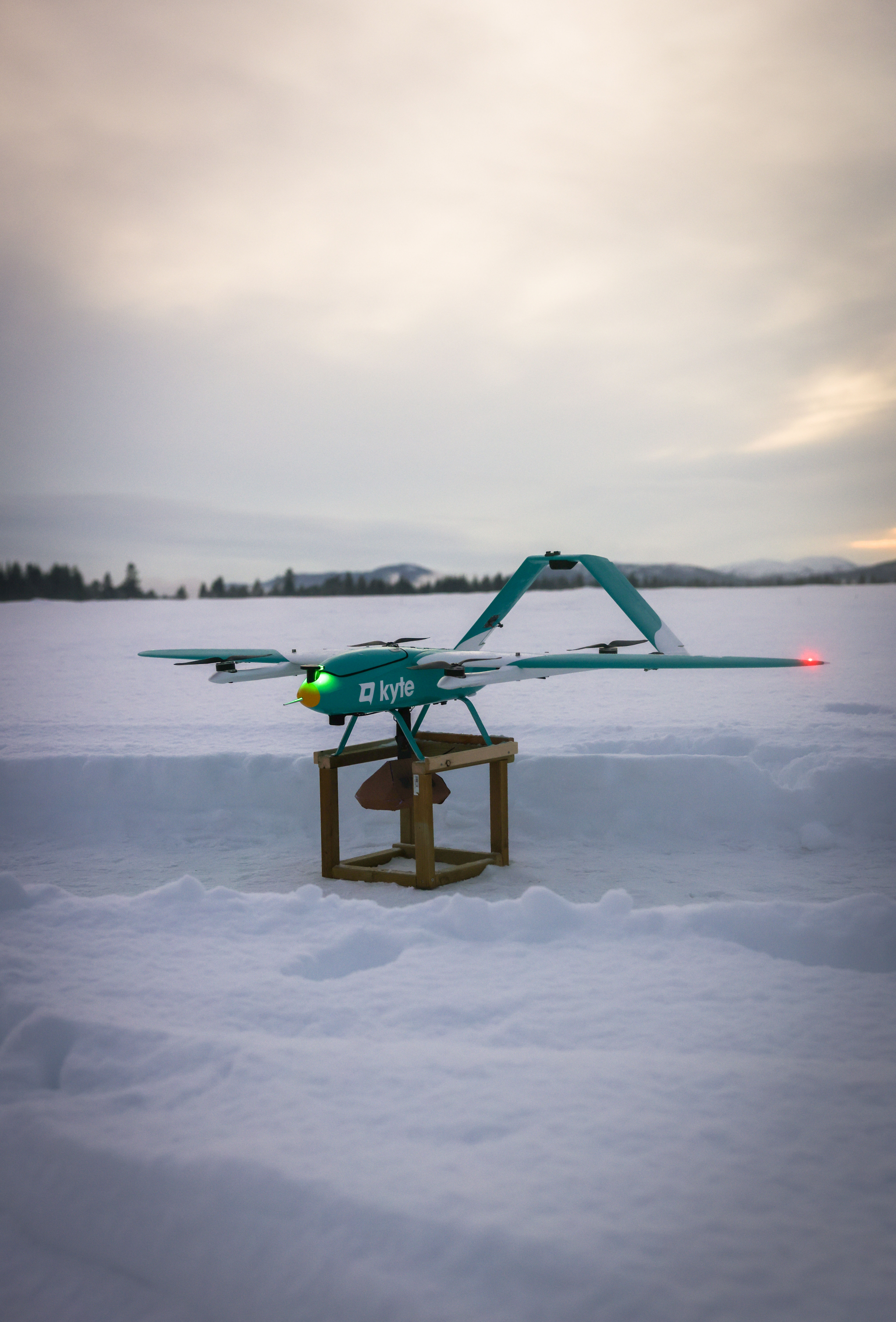 A drone with a package with snow in the background
