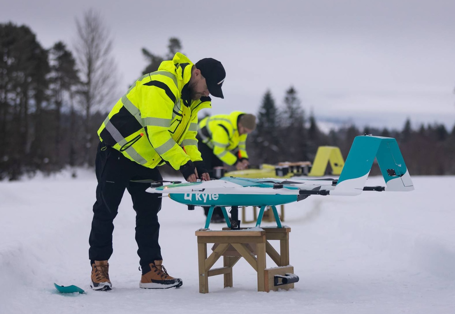 Two drone-operators working on Kyte-drones in the snow
